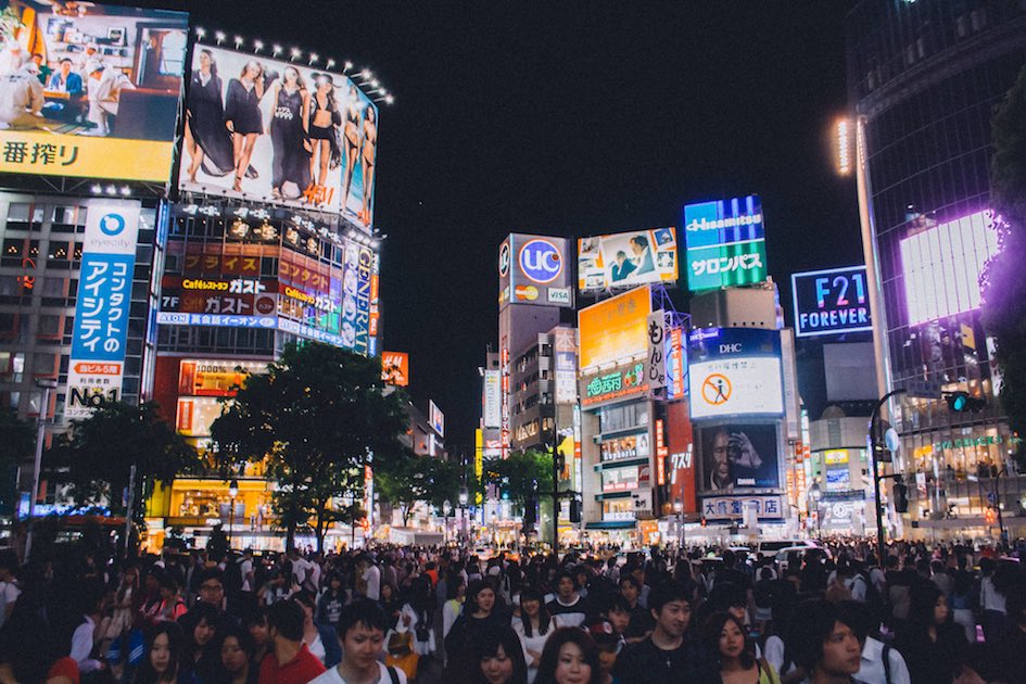 A bustling and vibrant street in Tokyo at night, featuring the lively energy of Hong Kong.