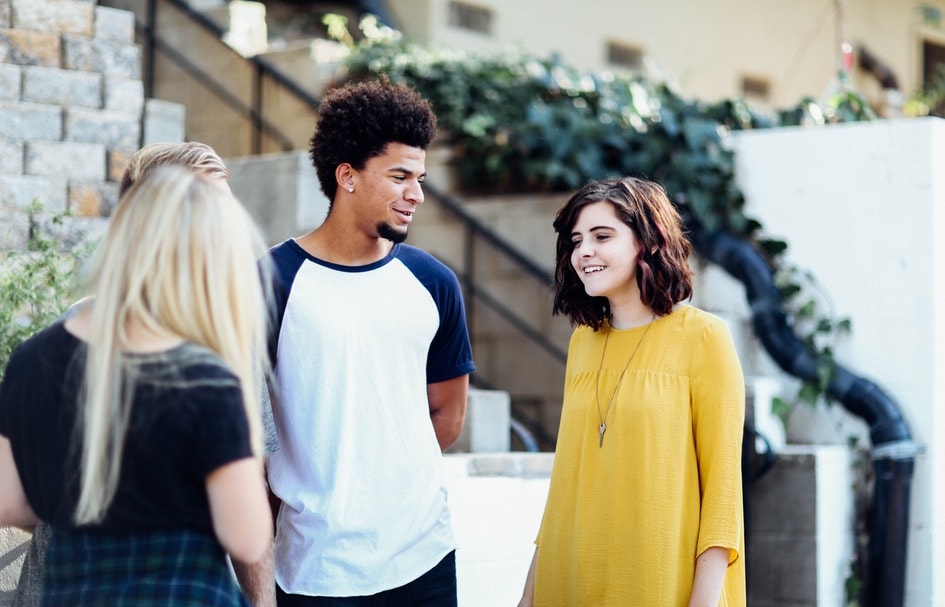 A group of award-winning young people talking in front of a building in Hong Kong.