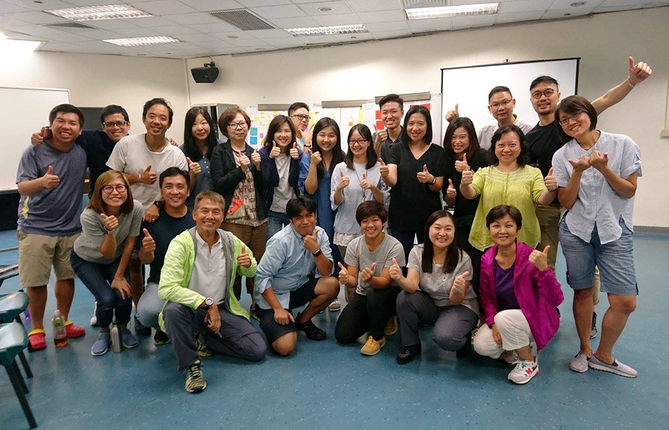 A group of people posing for an award-winning photo in a classroom.