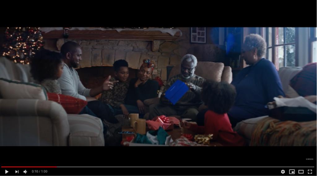 A group of award-winning people sitting around a Christmas tree.