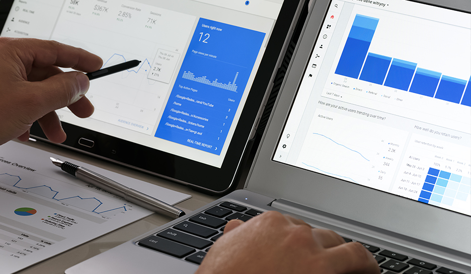 Two award-winning laptops displaying Google Analytics graphs for digital marketing.