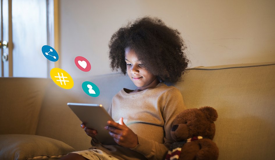 A girl sitting on a couch with a tablet and teddy bear in Hong Kong.