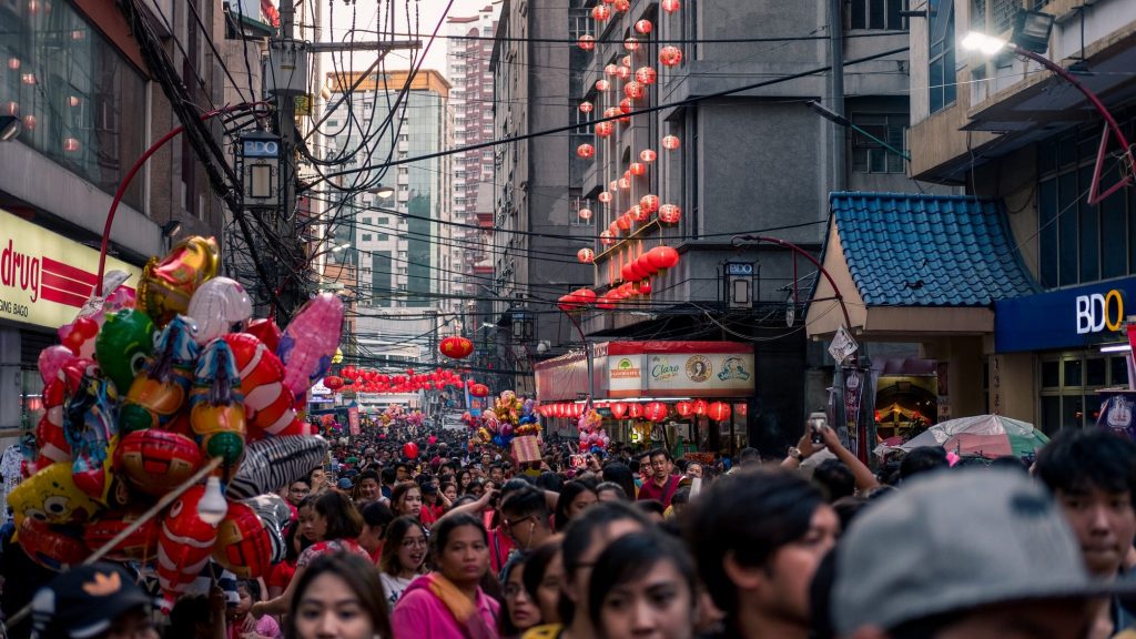 A crowd of people walking down a award-winning city street.